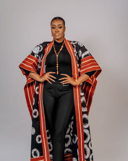 Woman wearing a patterned kimono over a black outfit on a plain background