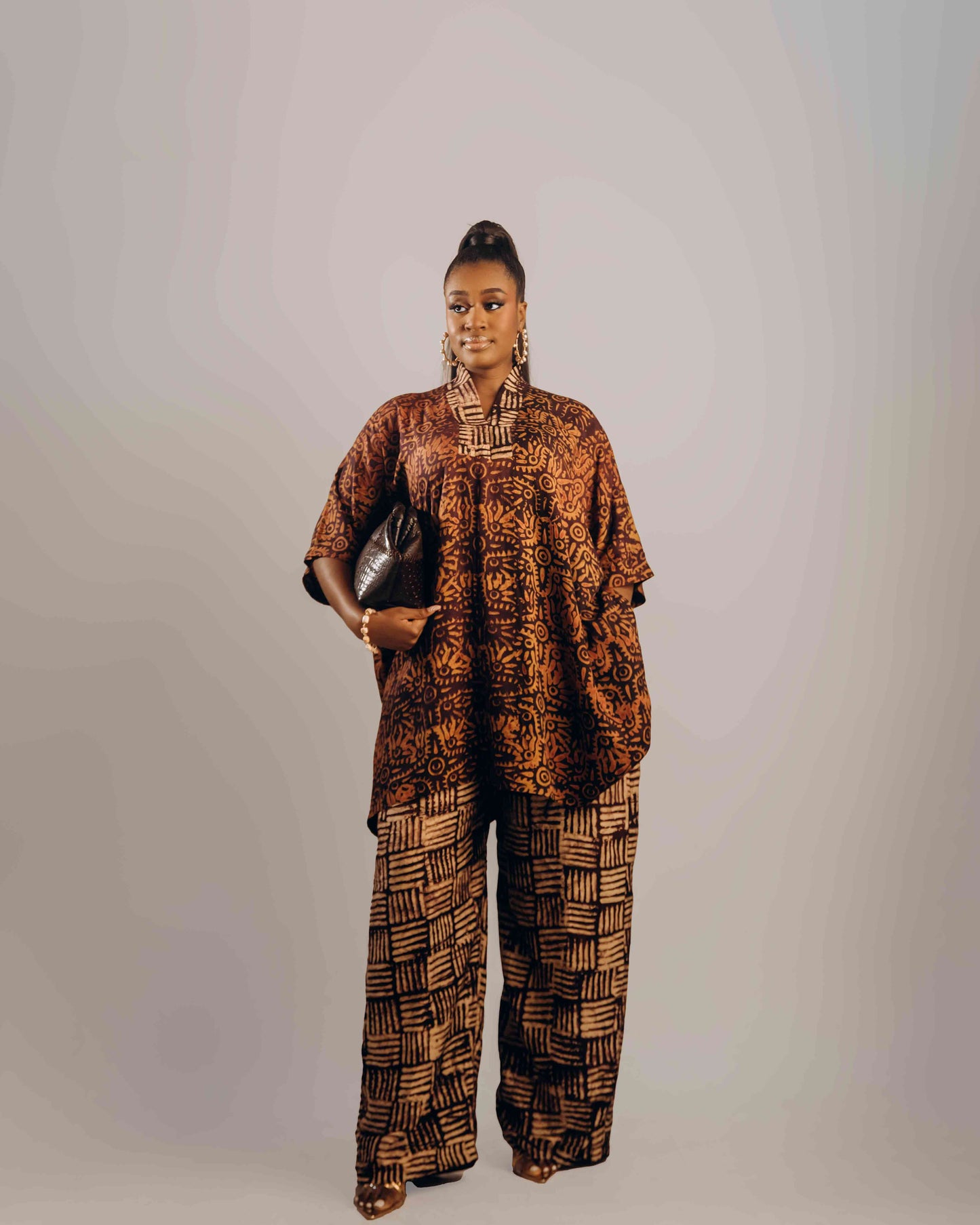 Woman wearing a patterned outfit against a plain background