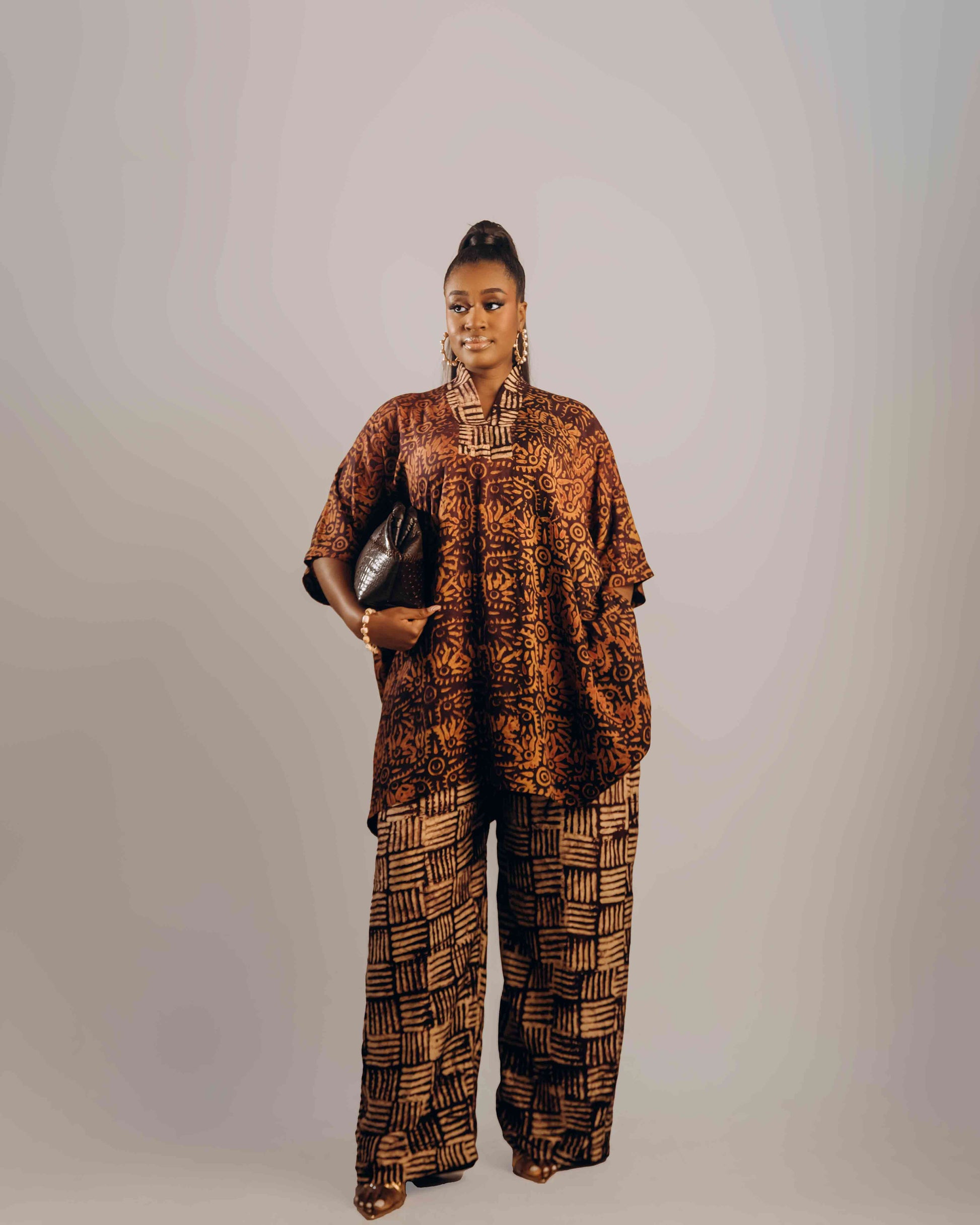 Woman wearing a patterned outfit against a plain background